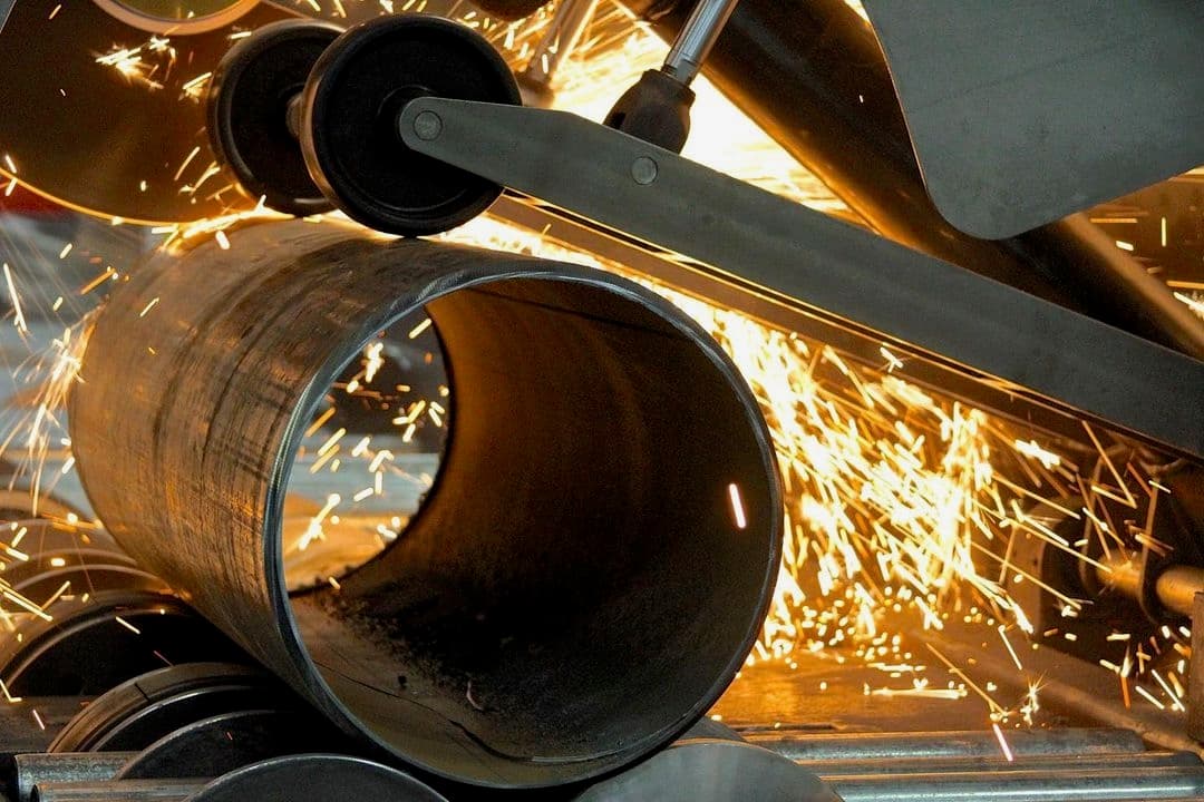 Proceso de corte de tubería de Diámetros Mayores, donde se generan chispas, mostrando maquinaria industrial en acción.