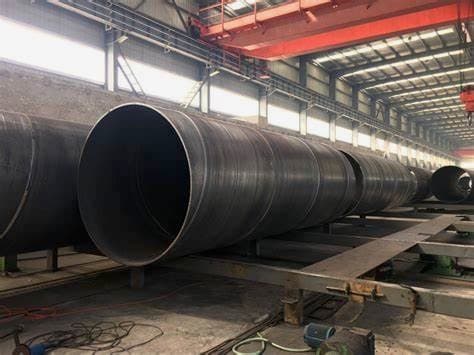 Tubería de Diámetros Mayores de acero almacenada en un taller industrial, con un ambiente bien iluminado y techado.